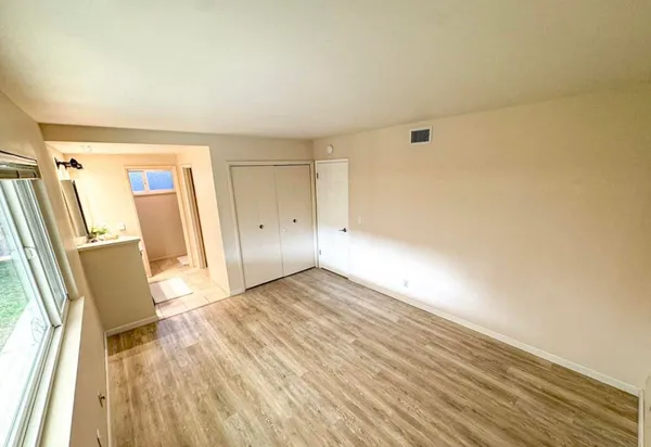 a view of empty room with wooden floor