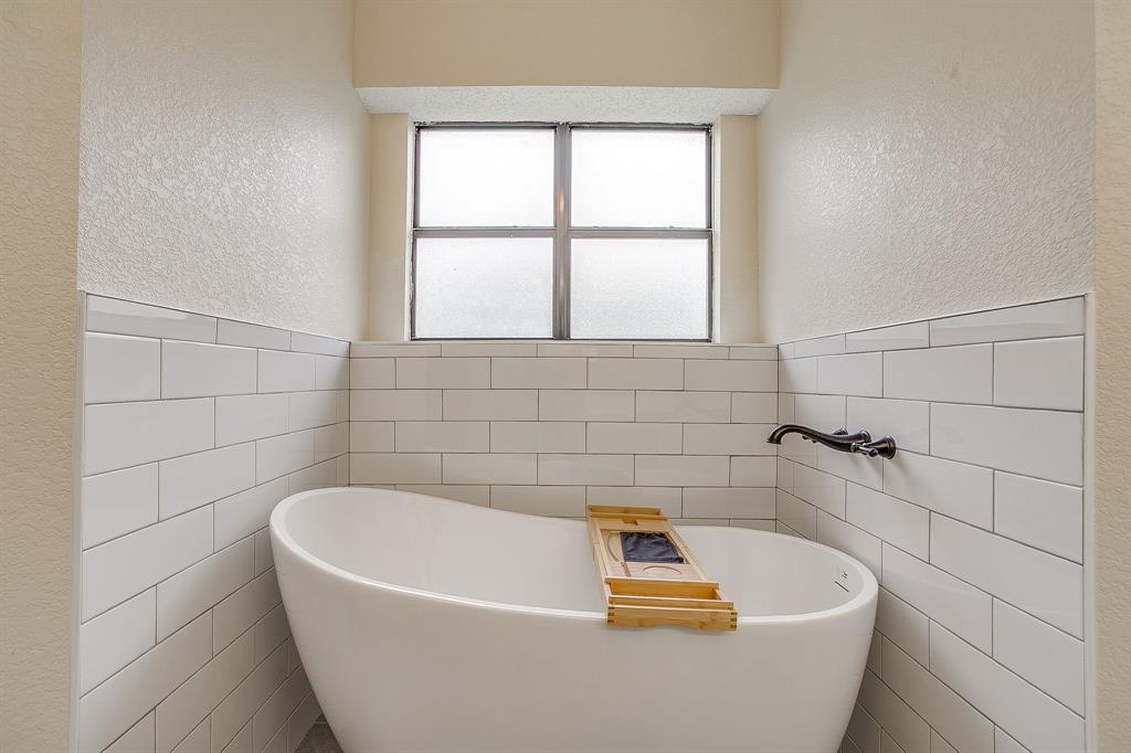 8613 Silver Creek Road White Settlement, TX 76108 - Photo 16 of 40 a white bath tub sitting in a bathroom