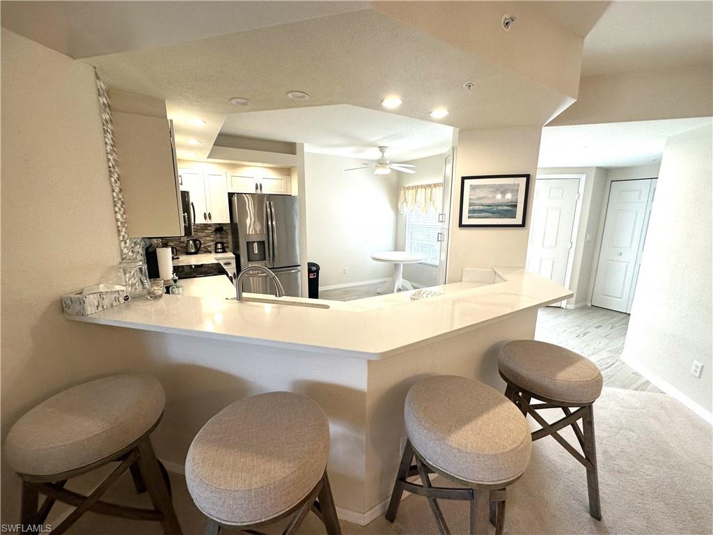 6816 Satinleaf Road South, Unit 102 Naples, FL 34109 - Photo 11 of 35 a bathroom with a toilet a sink and a large mirror