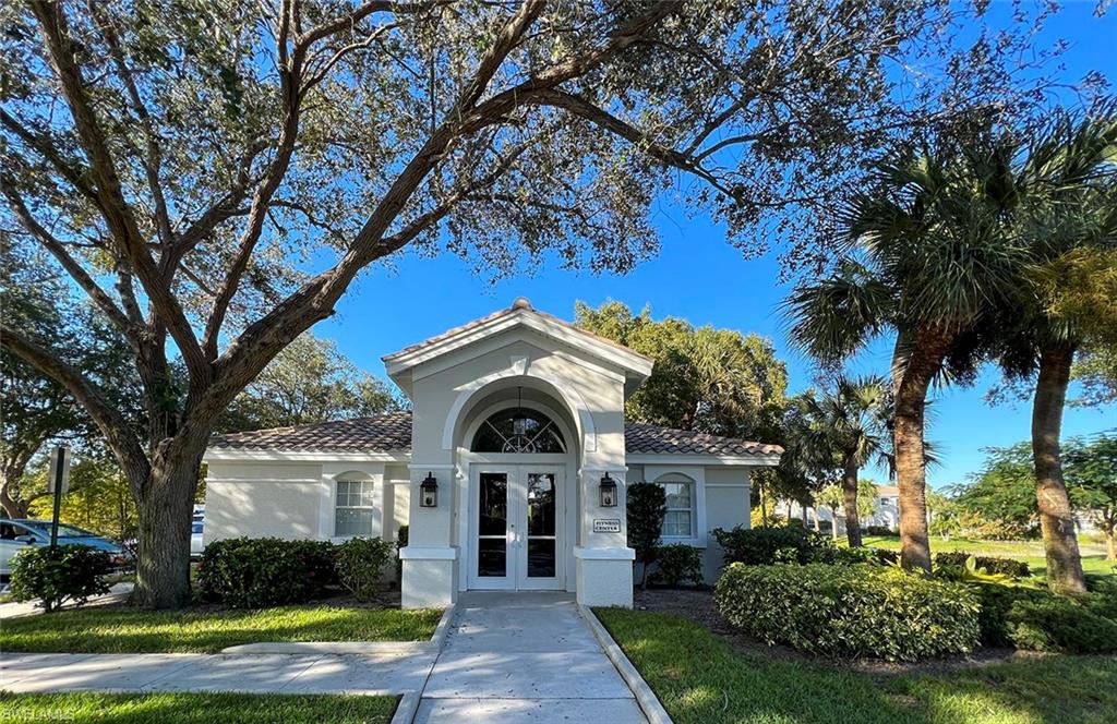 6816 Satinleaf Road South, Unit 102 Naples, FL 34109 - Photo 30 of 35 a front view of a house with garden