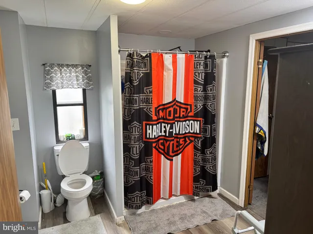 a view of an empty room with closet and wooden door