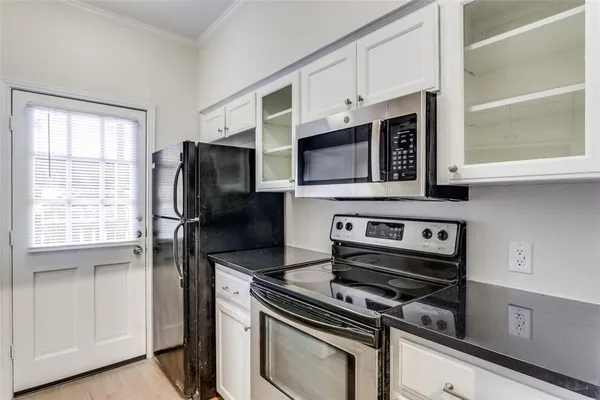 a kitchen with stainless steel appliances a stove a microwave and a window