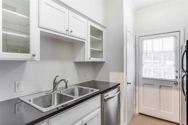 a kitchen with stainless steel appliances granite countertop a sink and cabinets with wooden floor