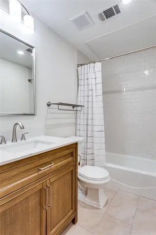 a bathroom with a granite countertop sink a toilet and shower