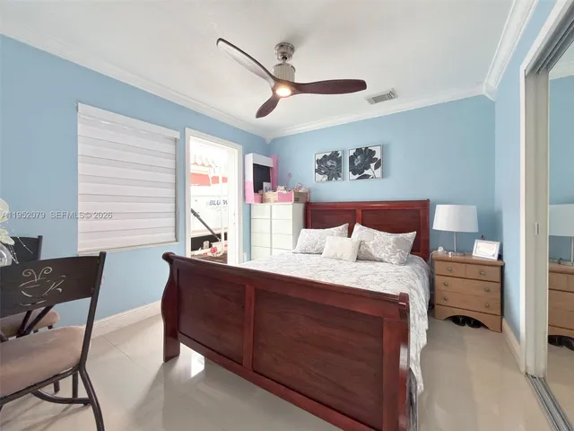 a bedroom with a bed and a flat tv screen on dresser