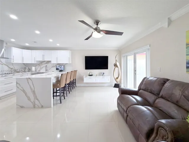 a kitchen with stainless steel appliances granite countertop a dining table chairs refrigerator sink and cabinets