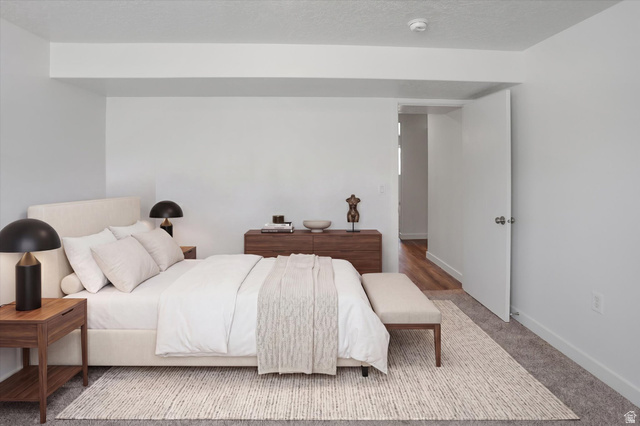 3636 West 910 South Syracuse, UT 84075 - Photo 6 of 70 Bedroom featuring a neutral color palette, plush carpeting, wood-finish flooring visible from the doorway, and a crisp white door