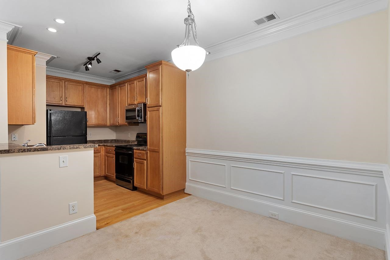 900 Canenaugh Drive, Unit 201 Raleigh, NC 27604 - Photo 19 of 28 a kitchen with stainless steel appliances granite countertop a refrigerator a oven a stove and a sink with granite countertops