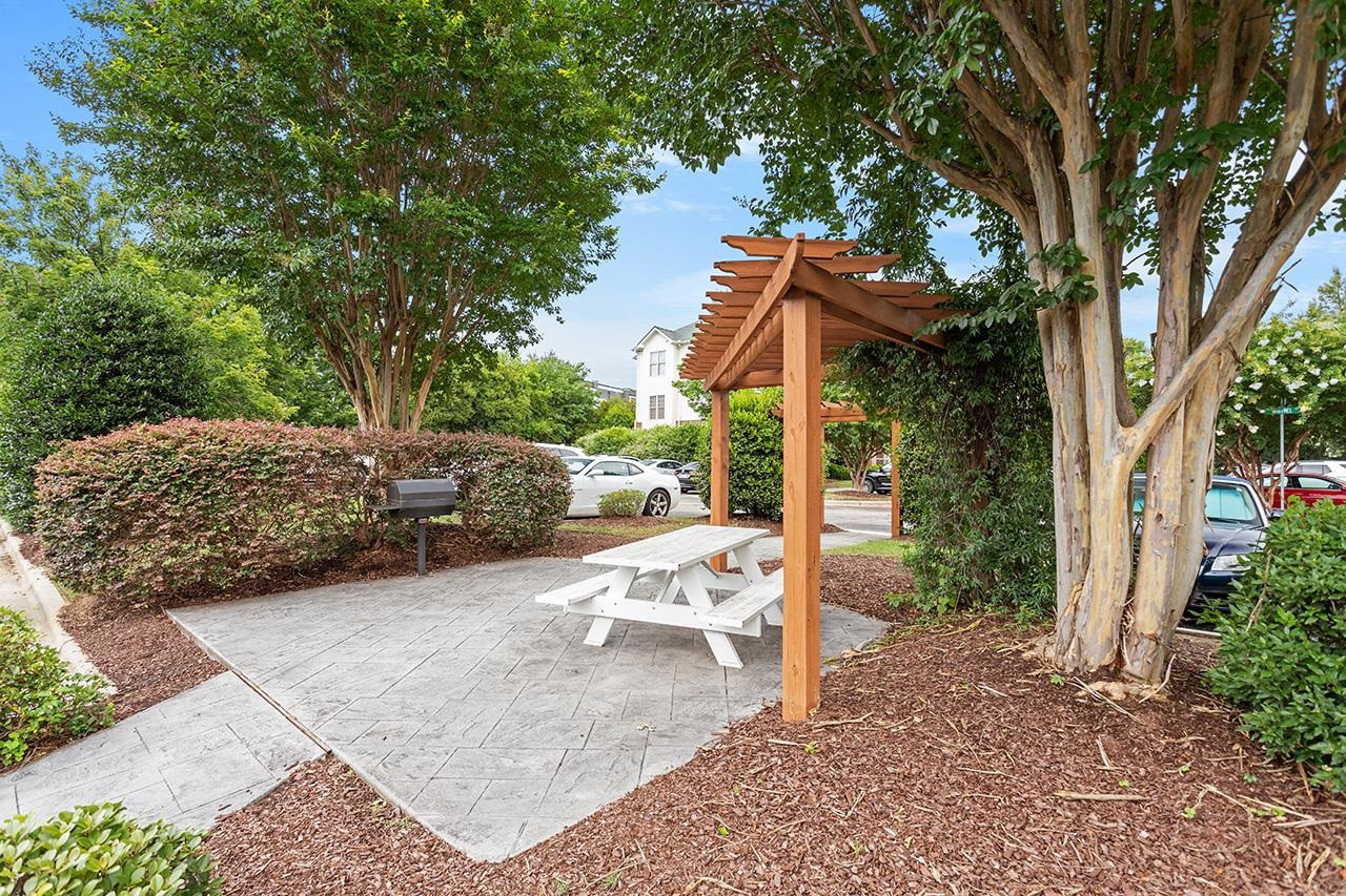 900 Canenaugh Drive, Unit 201 Raleigh, NC 27604 - Photo 27 of 28 a view of a patio with table and chairs under an umbrella