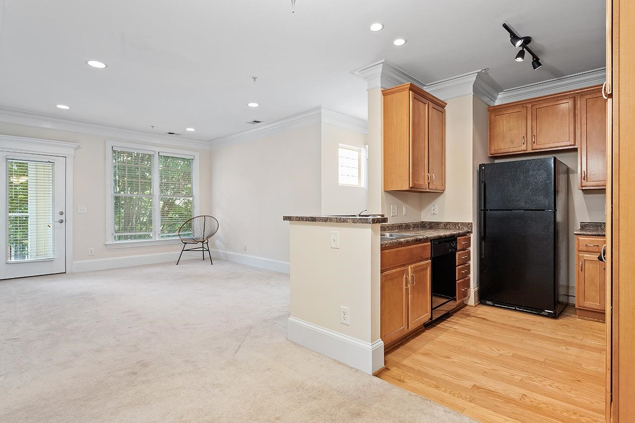 900 Canenaugh Drive, Unit 201 Raleigh, NC 27604 - Photo 3 of 28 a kitchen with stainless steel appliances granite countertop a refrigerator a stove and a sink with large window