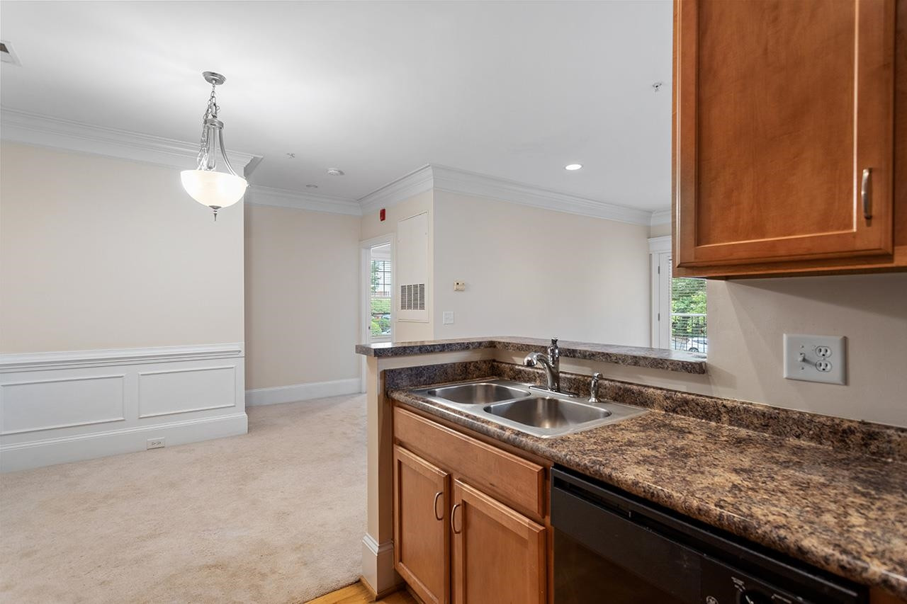 900 Canenaugh Drive, Unit 201 Raleigh, NC 27604 - Photo 5 of 28 a kitchen with granite countertop a sink and a stove