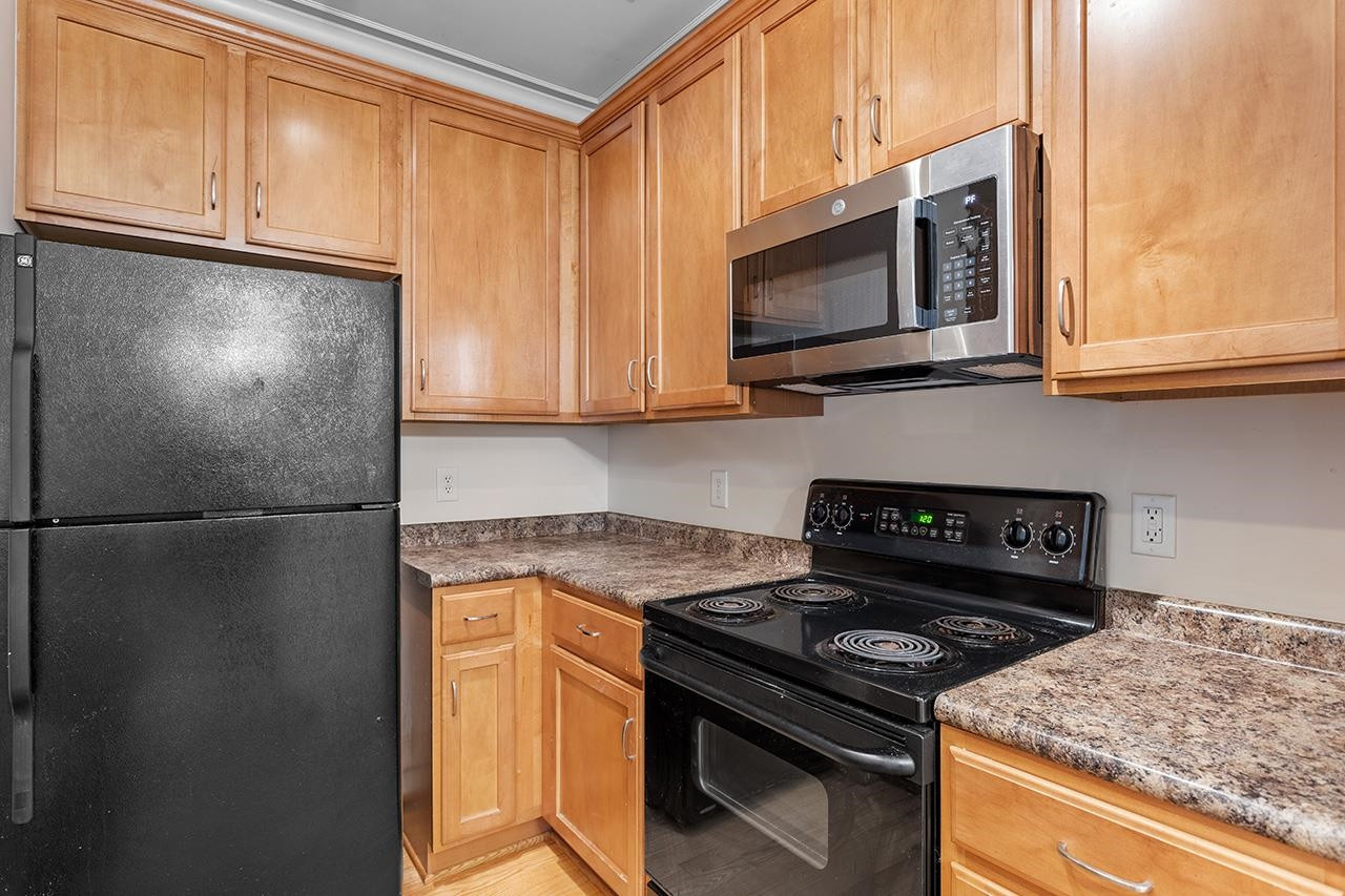 900 Canenaugh Drive, Unit 201 Raleigh, NC 27604 - Photo 6 of 28 a kitchen with a stove and a microwave