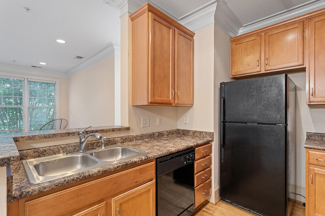 900 Canenaugh Drive, Unit 201 Raleigh, NC 27604 - Photo 7 of 28 a kitchen with stainless steel appliances granite countertop a refrigerator and a sink