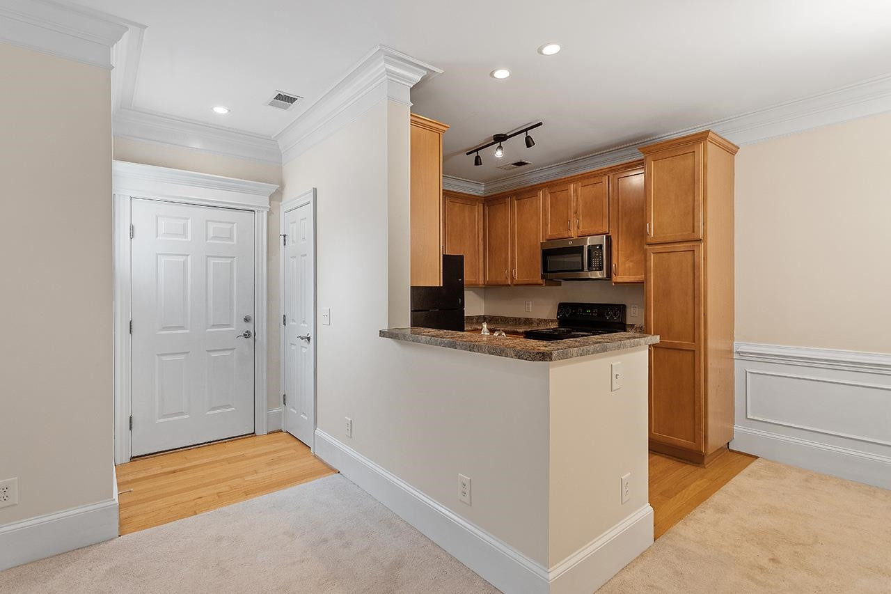 900 Canenaugh Drive, Unit 201 Raleigh, NC 27604 - Photo 8 of 28 a kitchen with stainless steel appliances granite countertop a refrigerator and a stove top oven