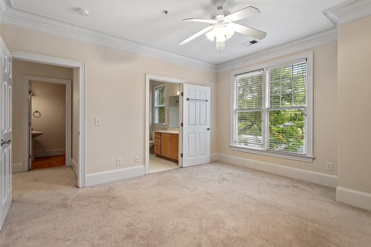 900 Canenaugh Drive, Unit 201 Raleigh, NC 27604 - Photo 10 of 28 an empty room with chandelier fan and windows