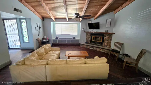 a living room with furniture a flat screen tv and kitchen view