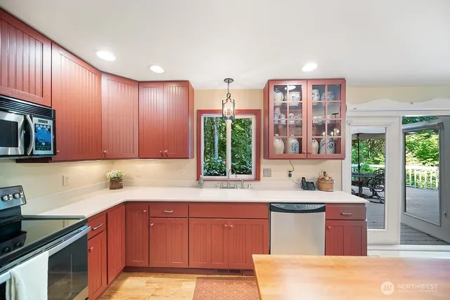 a kitchen with stainless steel appliances granite countertop wooden cabinets a sink and a stove