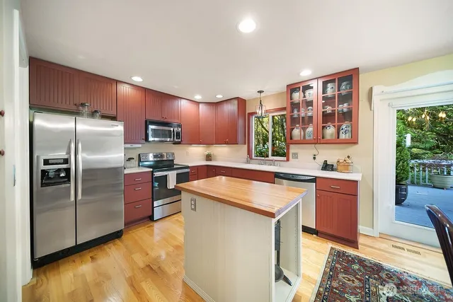 a kitchen with stainless steel appliances granite countertop a refrigerator sink and stove