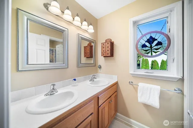 a bedroom with a large bed a chandelier and a window