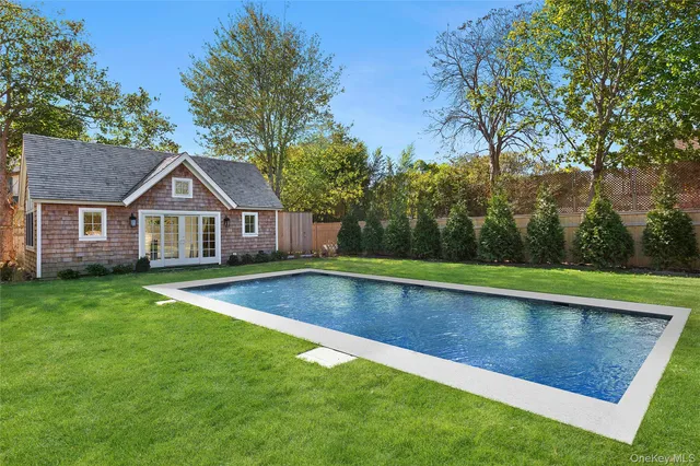 a view of house with pool and yard in the background