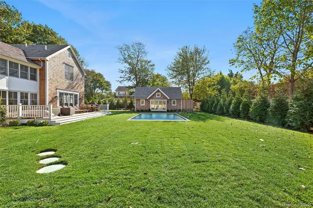 a view of a house with a big yard and large trees