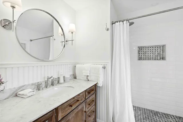 a bathroom with a granite countertop sink a mirror and a shower
