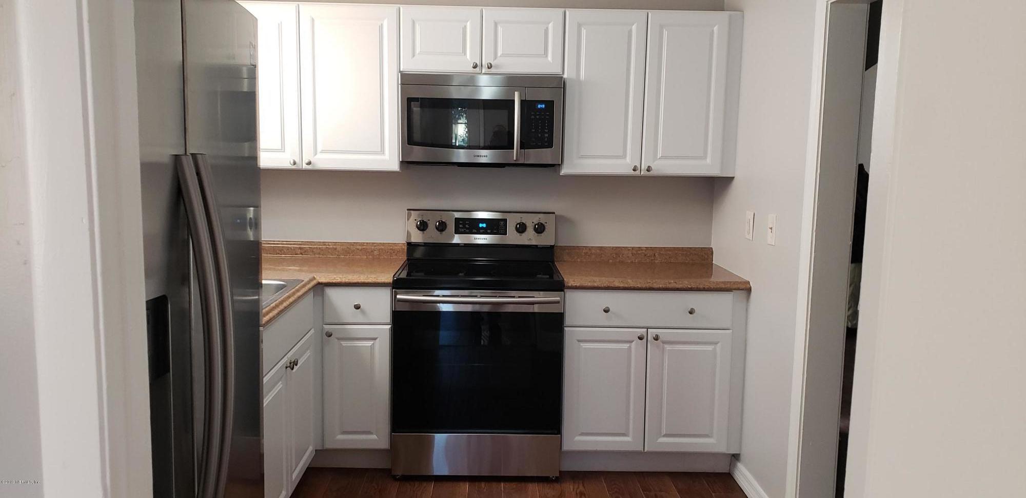 4633 Manchester Road Jacksonville, FL 32210 - Photo 12 of 26 a kitchen with stainless steel appliances granite countertop a stove a microwave and a refrigerator