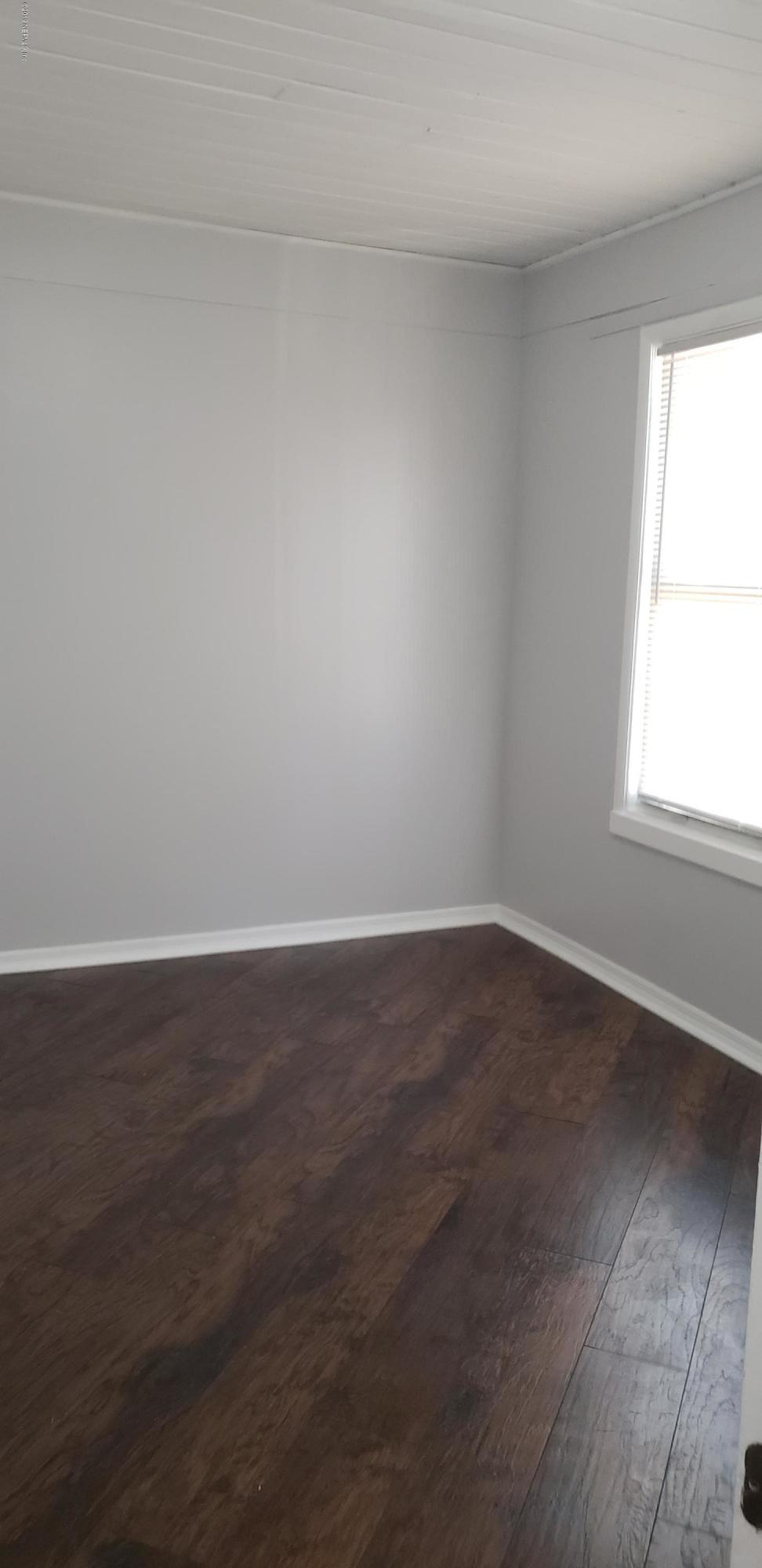 4633 Manchester Road Jacksonville, FL 32210 - Photo 21 of 26 an empty room with wooden floor and windows