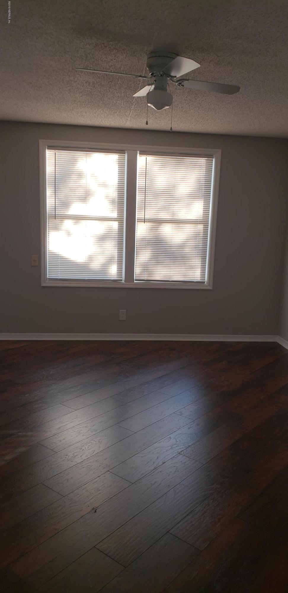 4633 Manchester Road Jacksonville, FL 32210 - Photo 23 of 26 an empty room with wooden floor and windows