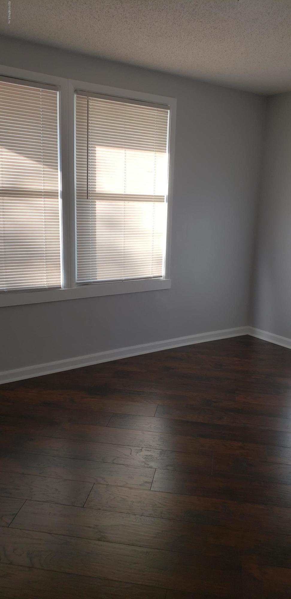 4633 Manchester Road Jacksonville, FL 32210 - Photo 25 of 26 a view of an empty room with wooden floor and a window