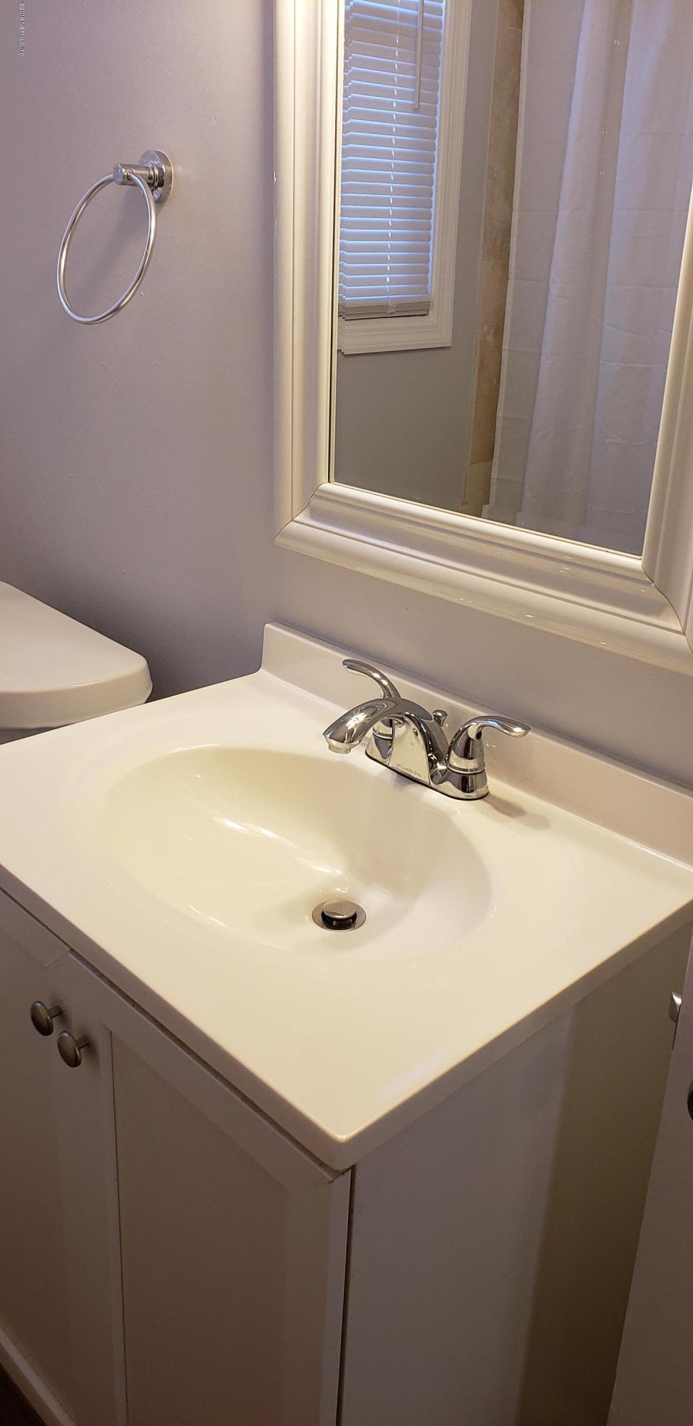 4633 Manchester Road Jacksonville, FL 32210 - Photo 3 of 26 a bathroom with a sink and a window