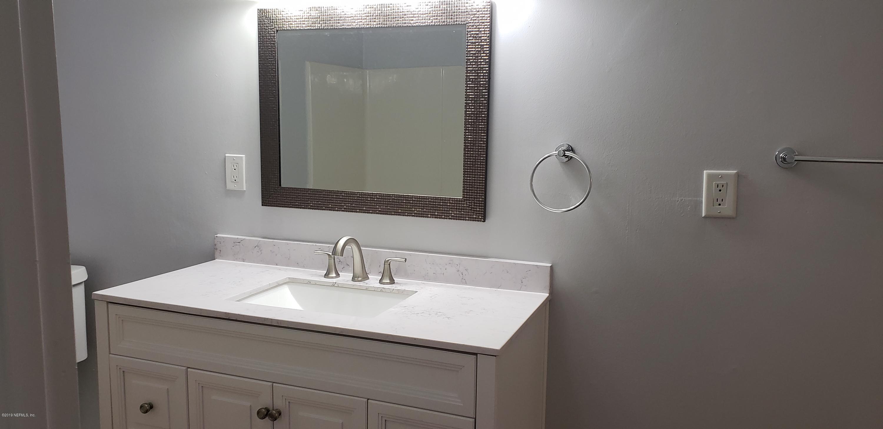 4633 Manchester Road Jacksonville, FL 32210 - Photo 7 of 26 a bathroom with a sink and a mirror
