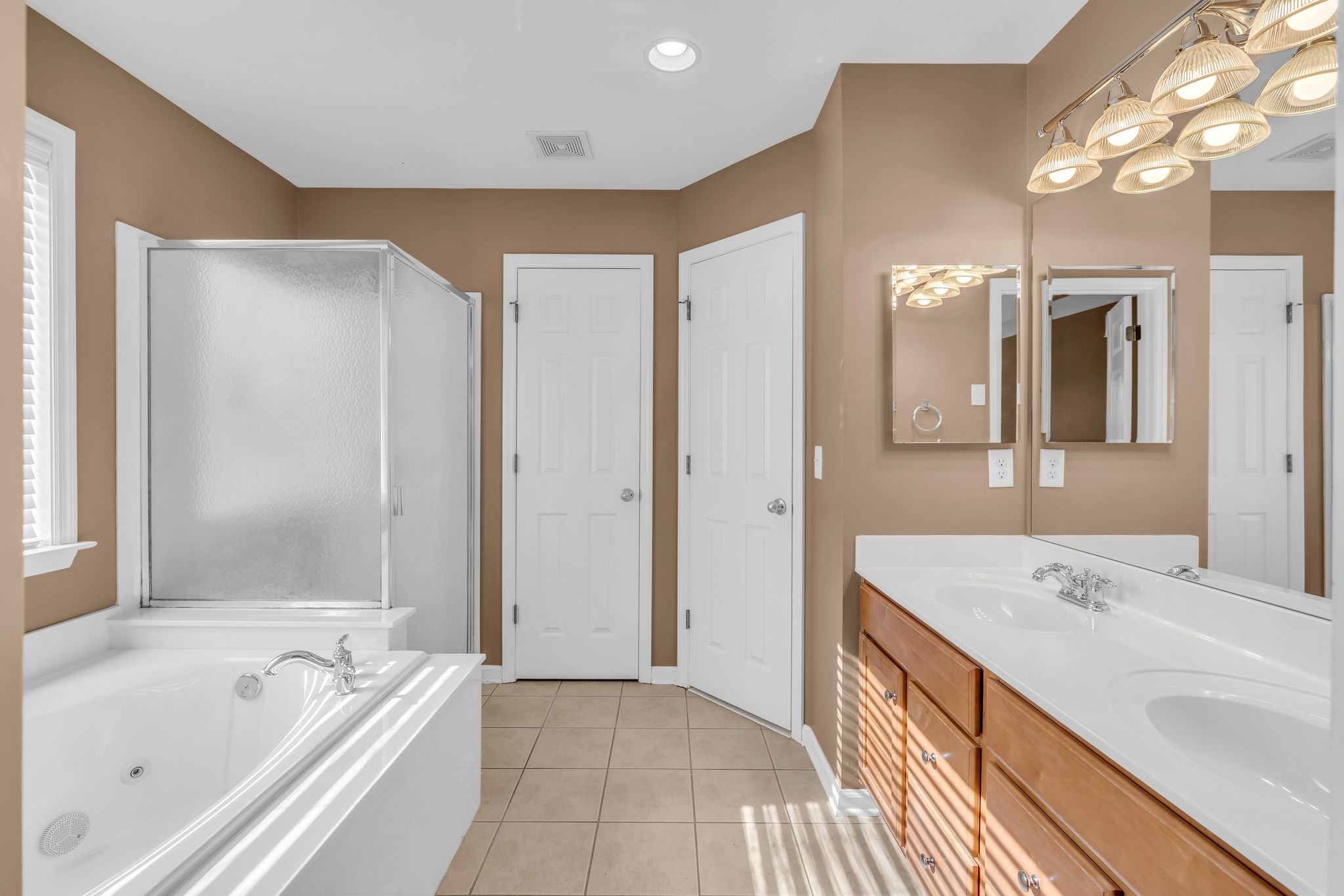 105 Lagan Court Franklin, TN 37064 - Photo 29 of 51 a bathroom with a tub a sink and mirrors