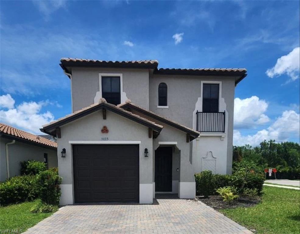 Mediterranean / spanish home featuring stucco siding, an attached garage, a tile roof, and decorative driveway