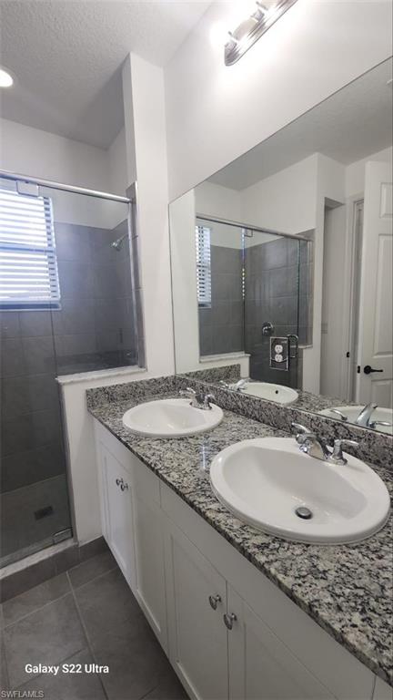 9015 Madrid Circle Naples, FL 34104 - Photo 11 of 15 Bathroom featuring tile patterned flooring, a shower stall, and a sink