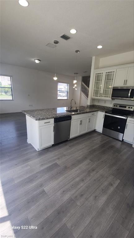 9015 Madrid Circle Naples, FL 34104 - Photo 6 of 15 Kitchen featuring visible vents, dark wood finished floors, a peninsula, stainless steel appliances, and a sink