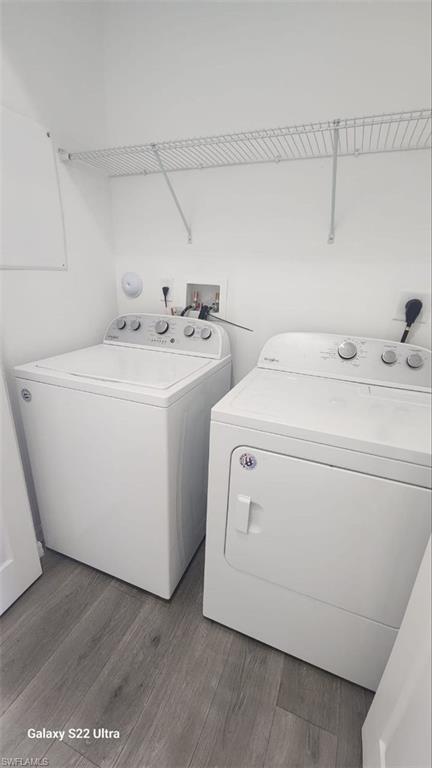 9015 Madrid Circle Naples, FL 34104 - Photo 10 of 15 Laundry room with wood finished floors, laundry area, and washing machine and clothes dryer