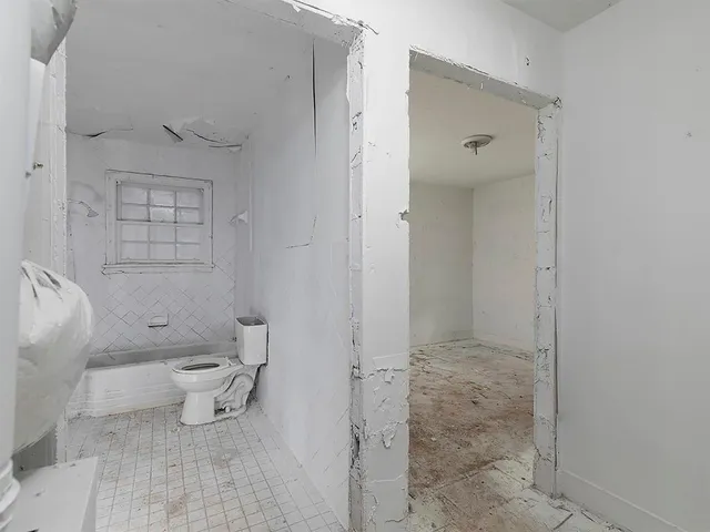 an empty room with windows and closet area