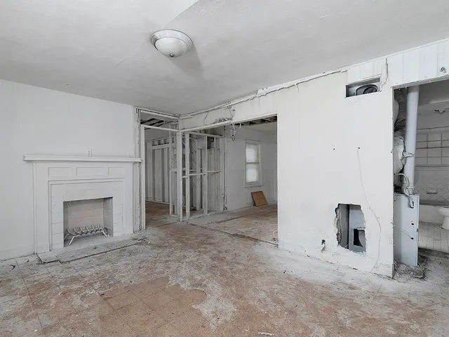 a view of empty room with a fireplace and fan
