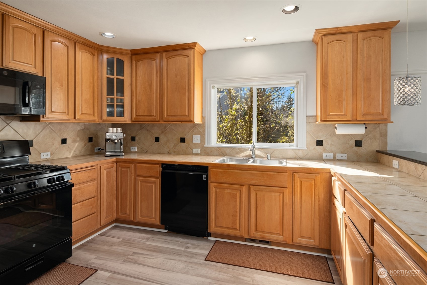 10217 Southeast 237th Street Kent, WA 98031 - Photo 7 of 28 a kitchen with stainless steel appliances granite countertop a stove a sink dishwasher and a microwave oven with cabinets