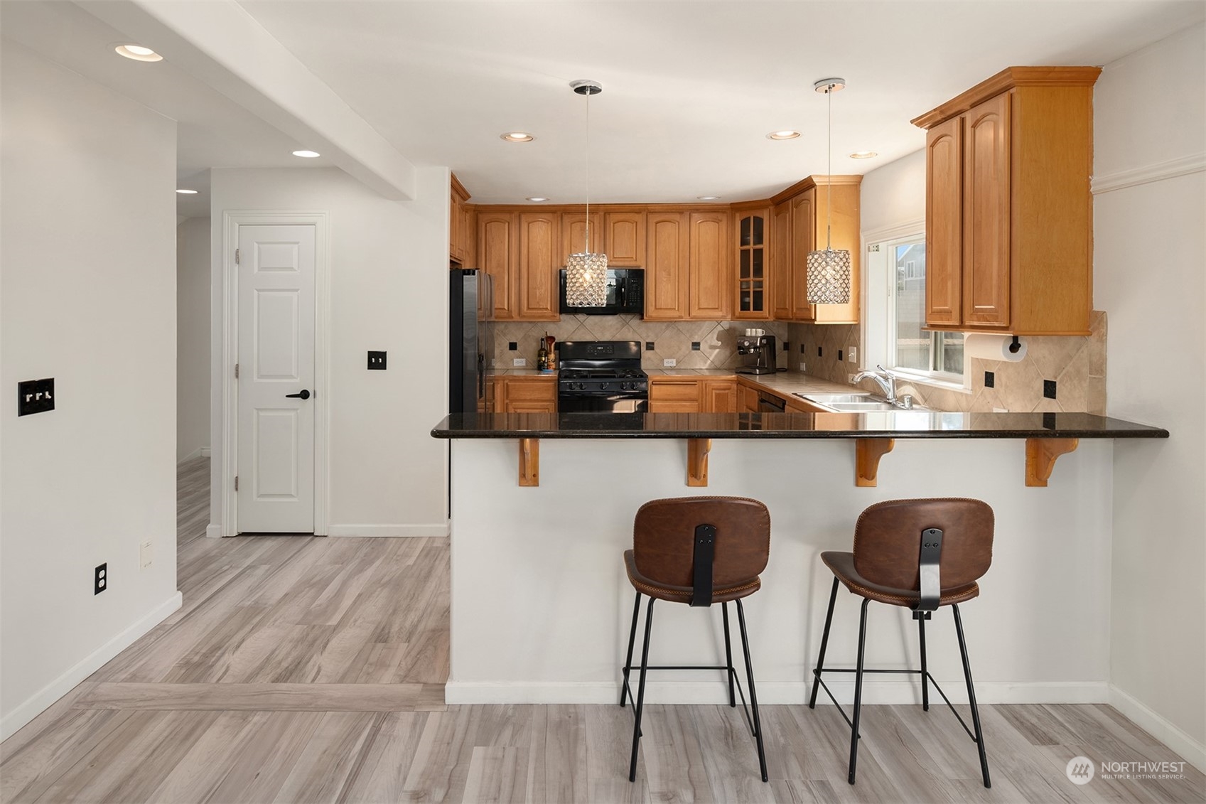 10217 Southeast 237th Street Kent, WA 98031 - Photo 8 of 28 a kitchen with stainless steel appliances granite countertop a stove top oven a sink dishwasher and white cabinets with wooden floor