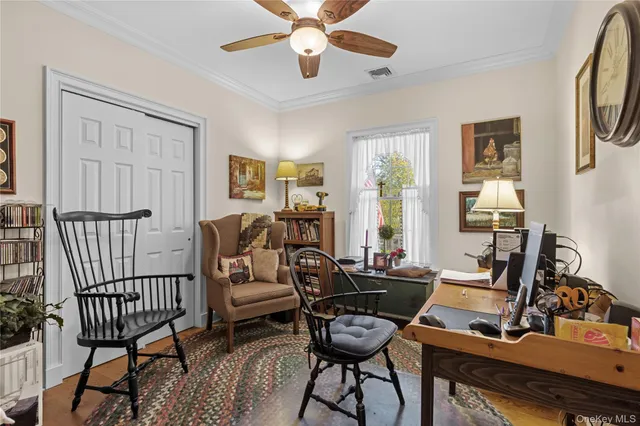 a view of a workspace with furniture and a window