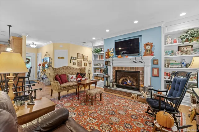 a living room with furniture a flat screen tv and a fireplace