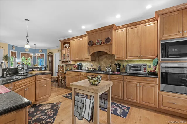 a kitchen with stainless steel appliances granite countertop a stove top oven a sink refrigerator and cabinets