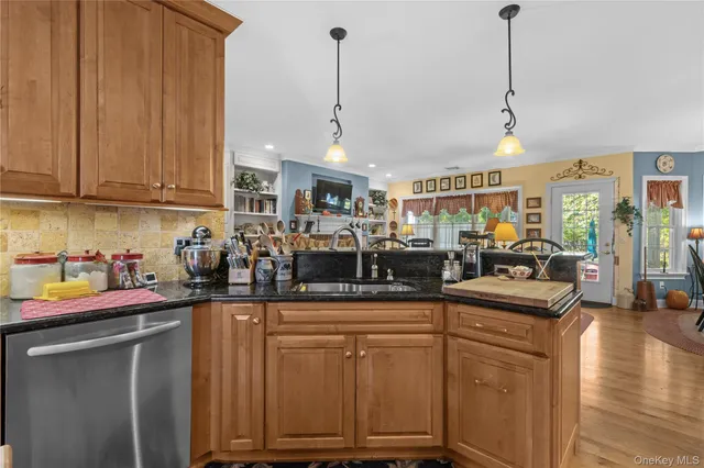 a kitchen with stainless steel appliances granite countertop a sink a stove and a wooden floors