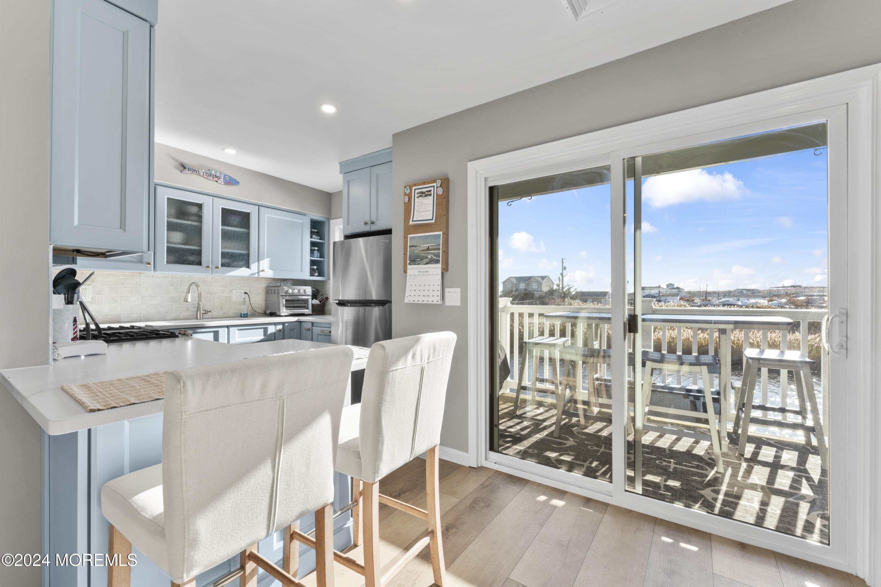441 East Bay Avenue, Unit 10 Barnegat, NJ 08005 - Photo 17 of 53 a dining room with furniture a floor to ceiling window and outdoor view