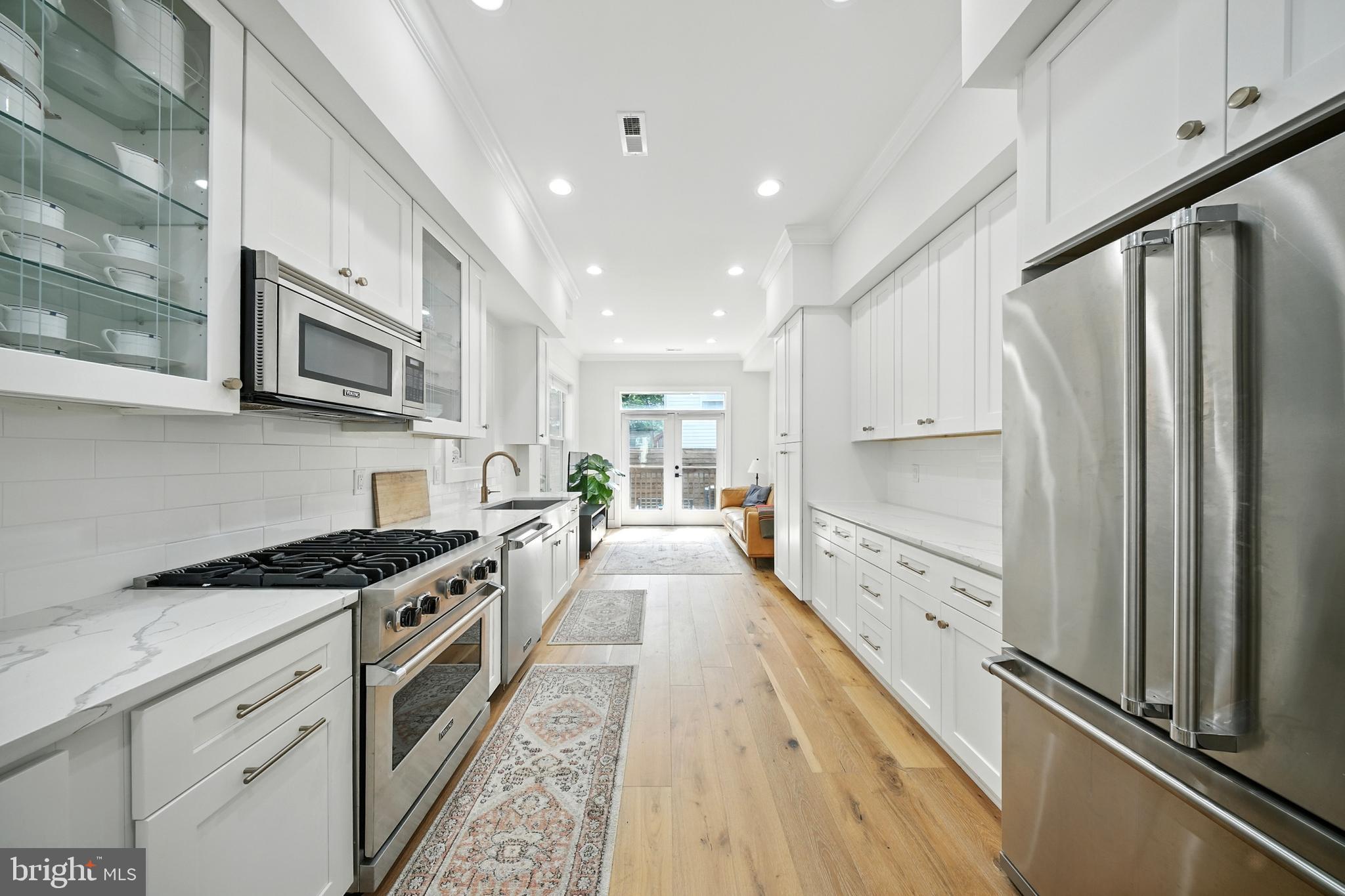 1831 North Capitol Street Northeast Washington, DC 20002 - Photo 8 of 39 a kitchen with granite countertop a stove top oven a sink dishwasher a refrigerator and cabinets with wooden floor