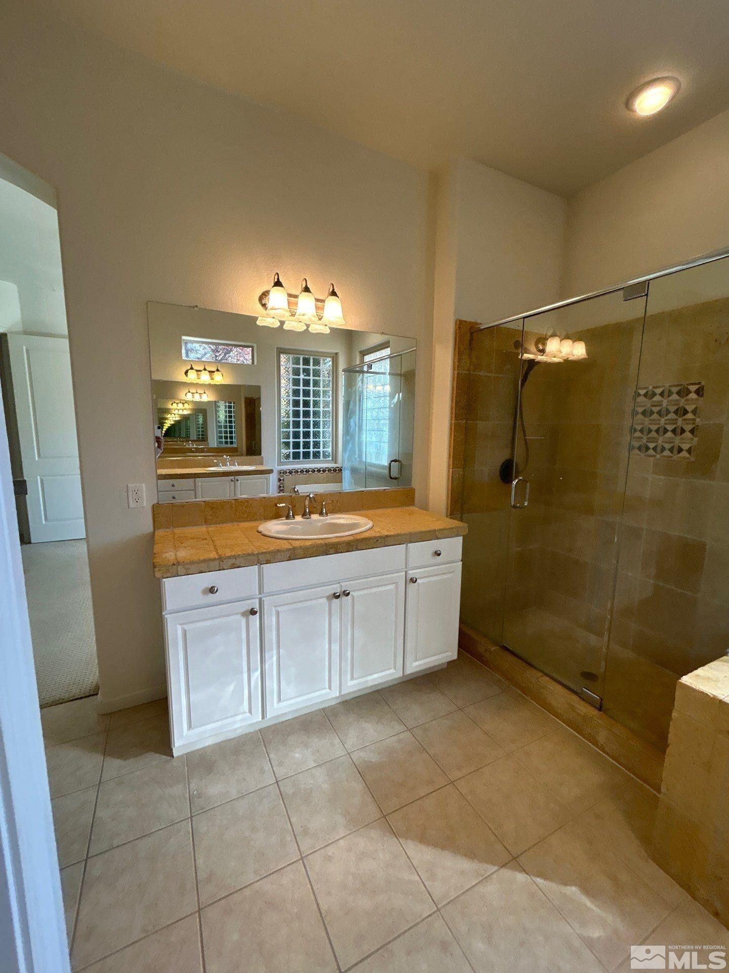 9900 Wilbur May Parkway, Unit 3402 Reno, NV 89521 - Photo 11 of 26 a bathroom with a granite countertop sink a mirror and a bathtub