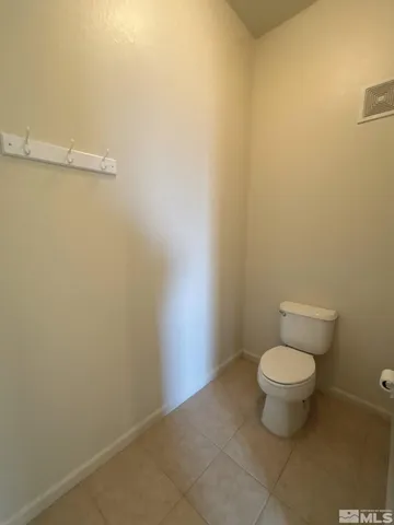 a white toilet sitting next to a white wall