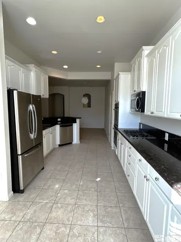 a kitchen with stainless steel appliances granite countertop a refrigerator and a stove top oven